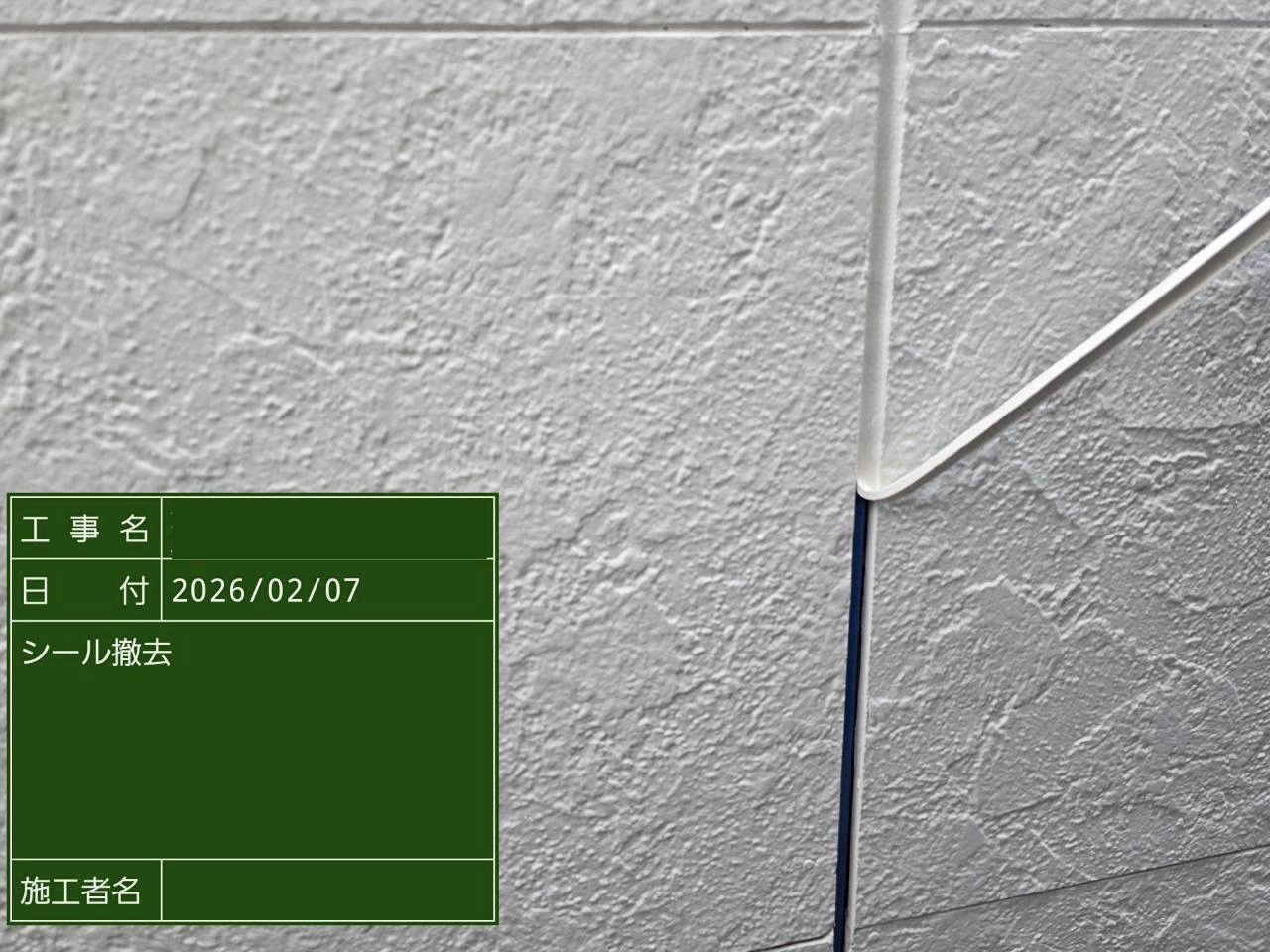 シーリングを撤去中の白い外壁